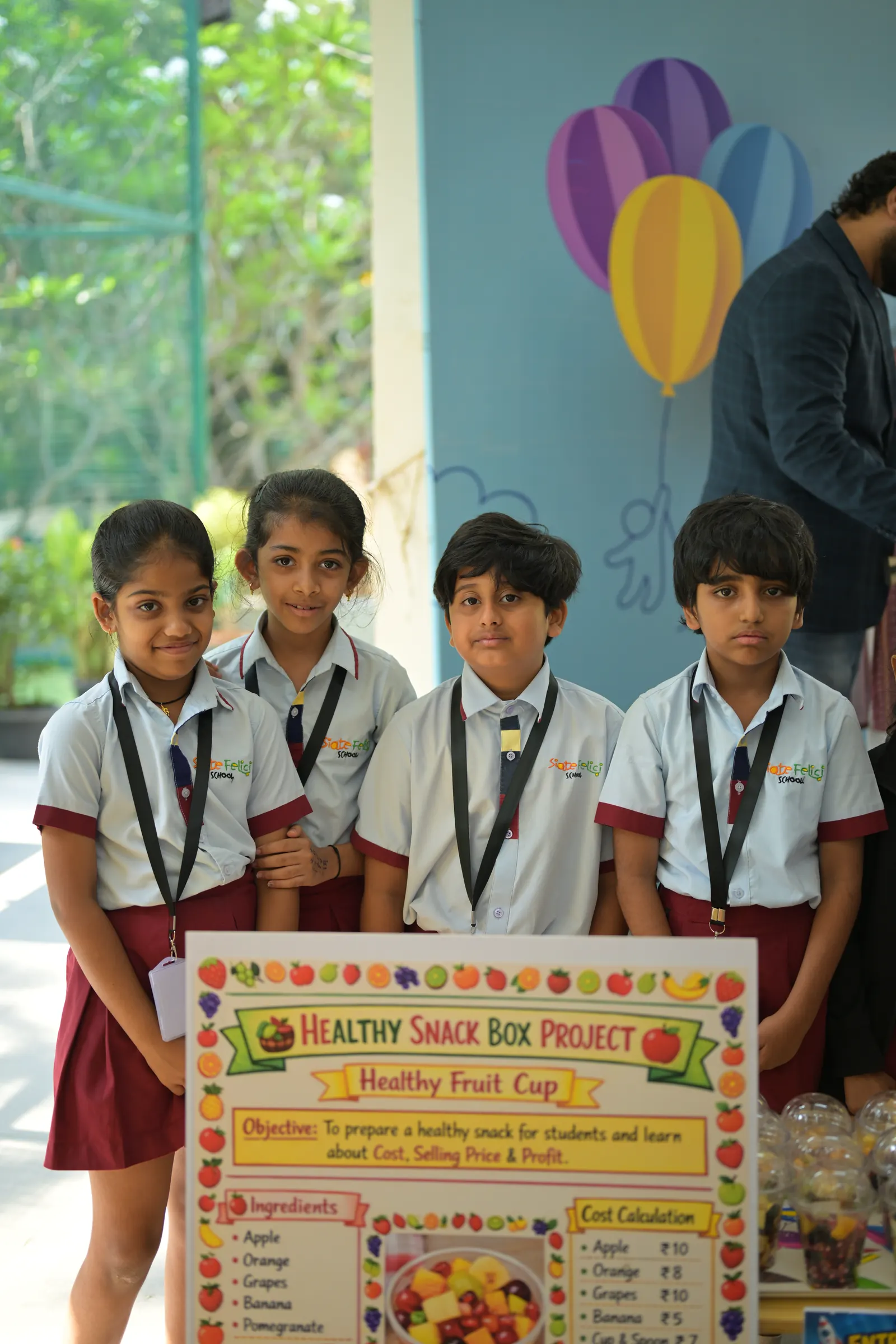 Students running a showcase stall, their poster propped on the table