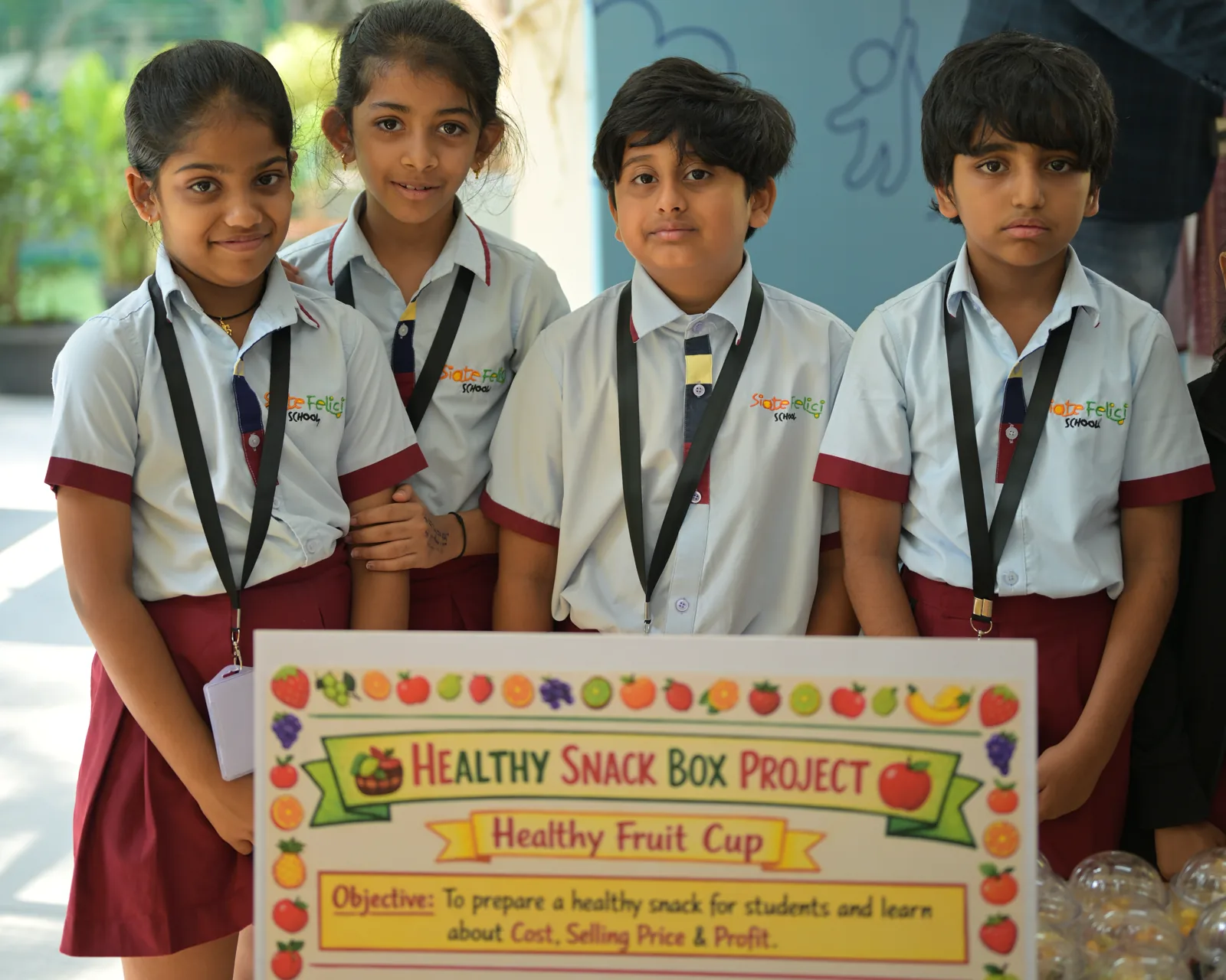 Four students behind their Healthy Snack Box Project board. It reads 