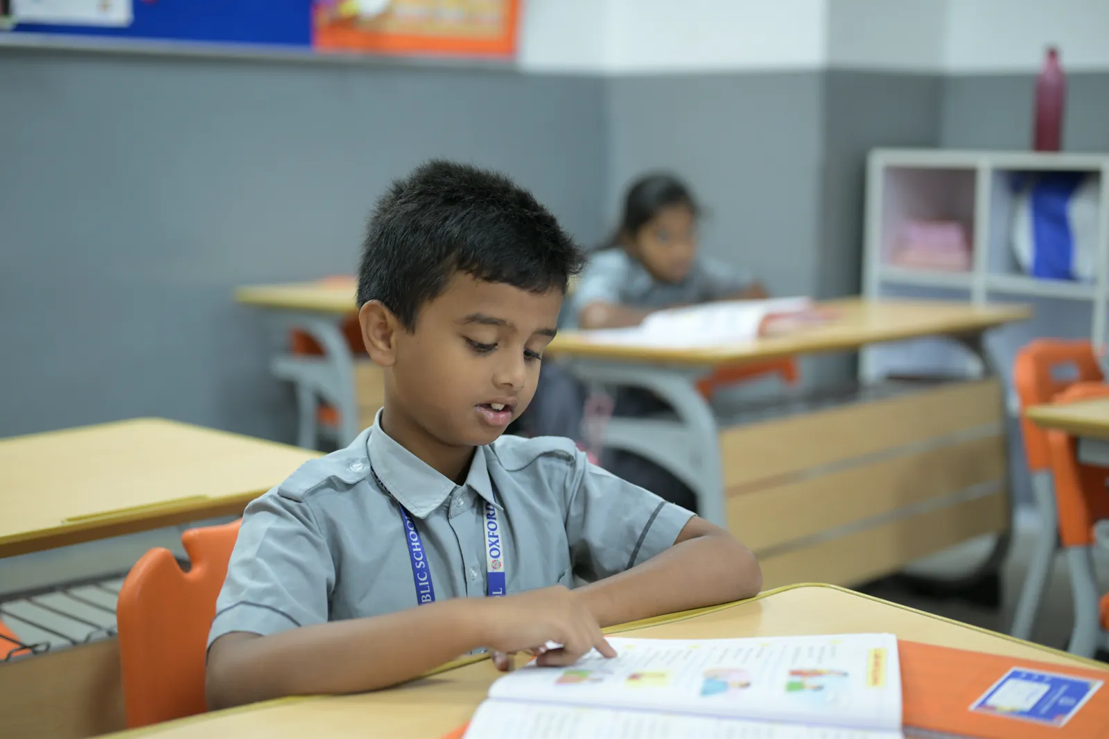 A student working through a printed task alone at his classroom desk