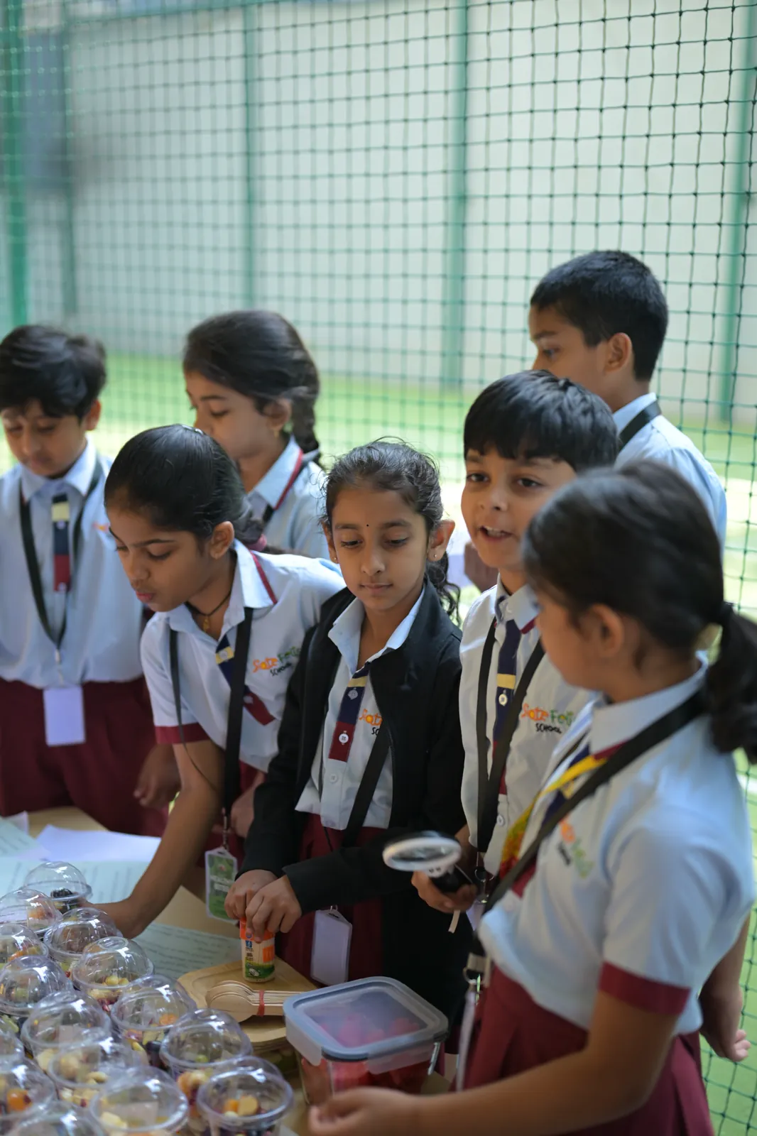 Students crowded around a stall table, examining the packaged snacks their classmates made and priced.